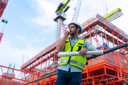 construction site manager coordinating work with a radio.